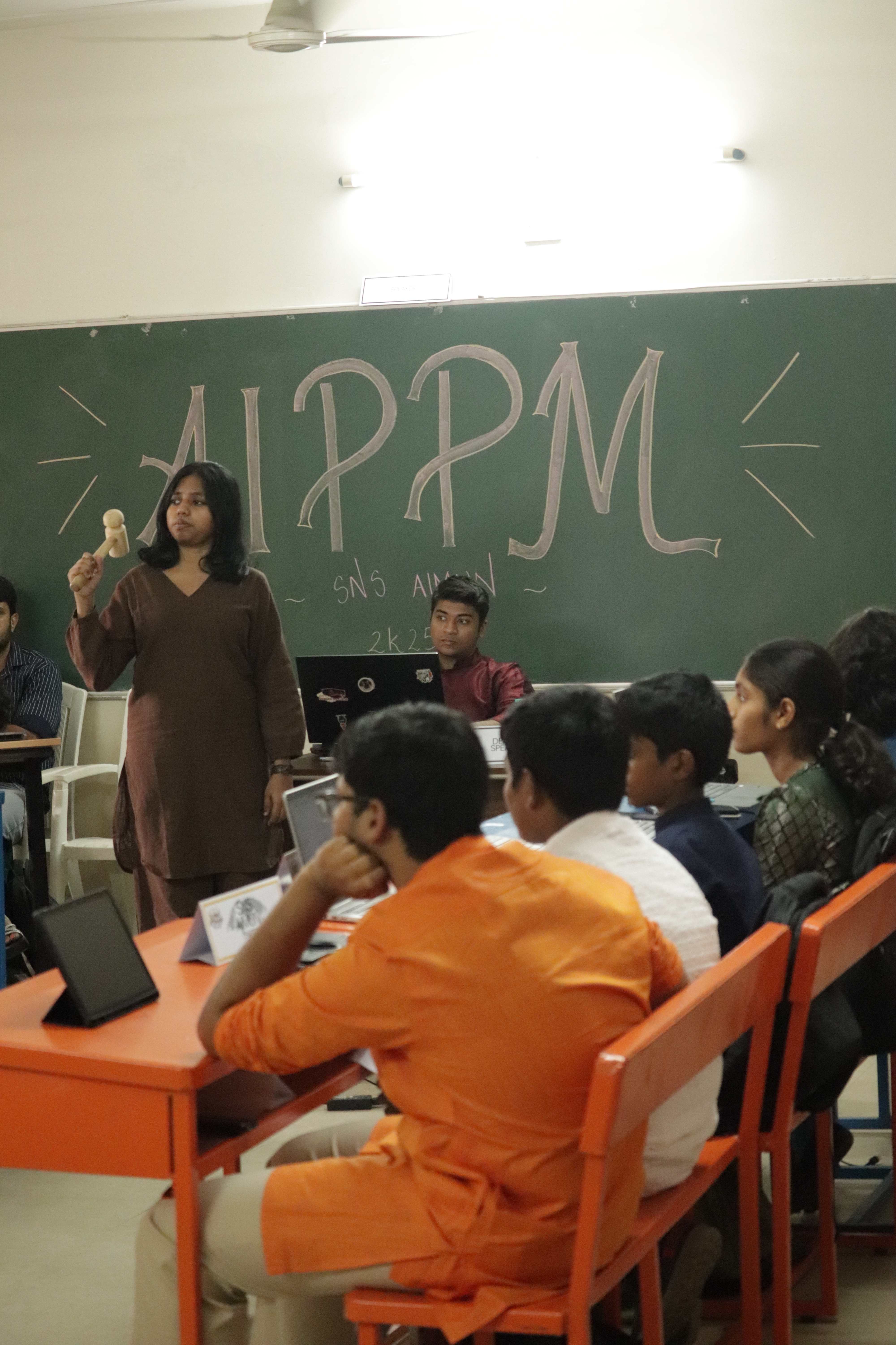 Delegates collaborating around tables during an SNS AIMUN session